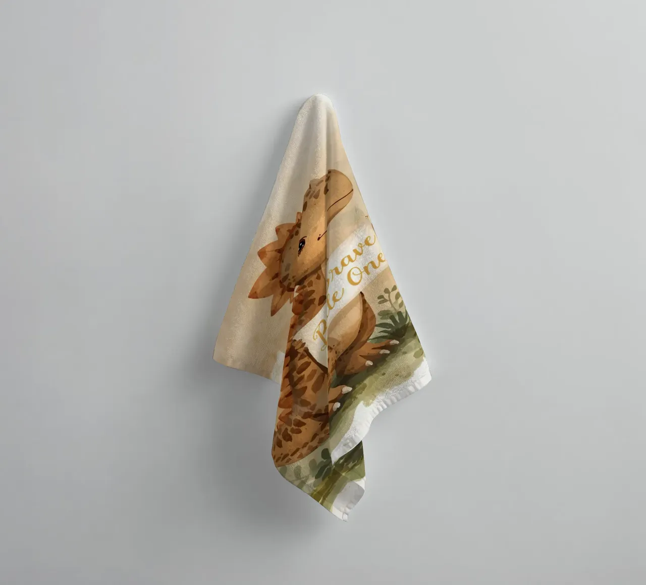 Un simpatico dinosauro con in mano lo striscione "Be Brave Little One". asciugamano da bagno da DesignDoodle