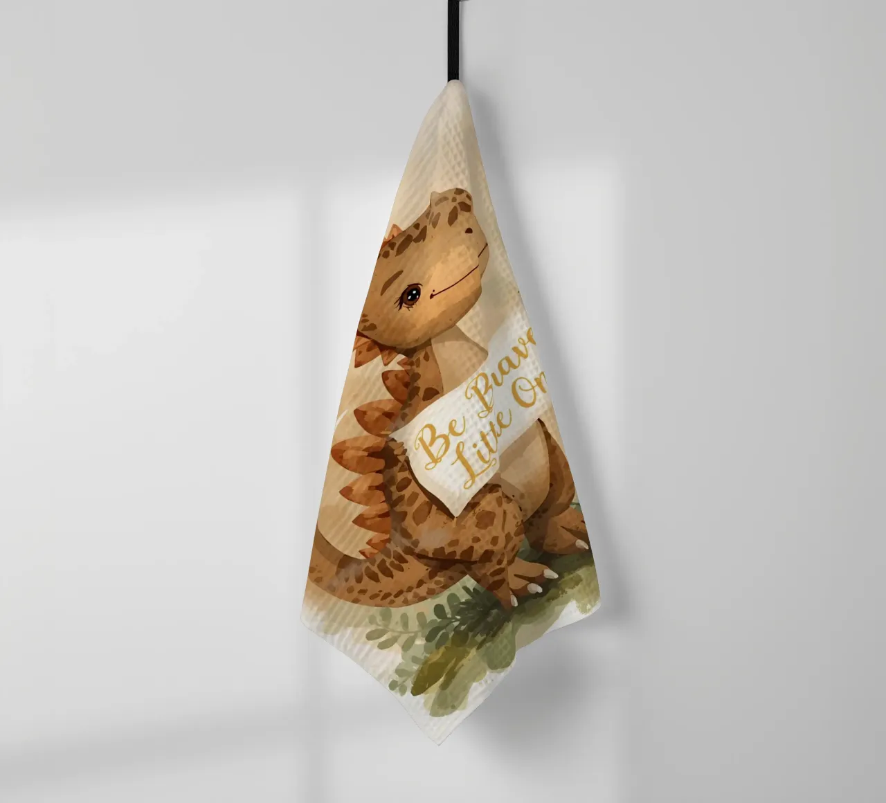 Mignon dinosaure tenant une bannière " Be Brave Little One " (Soyez courageux, mon petit) torchon de DesignDoodle
