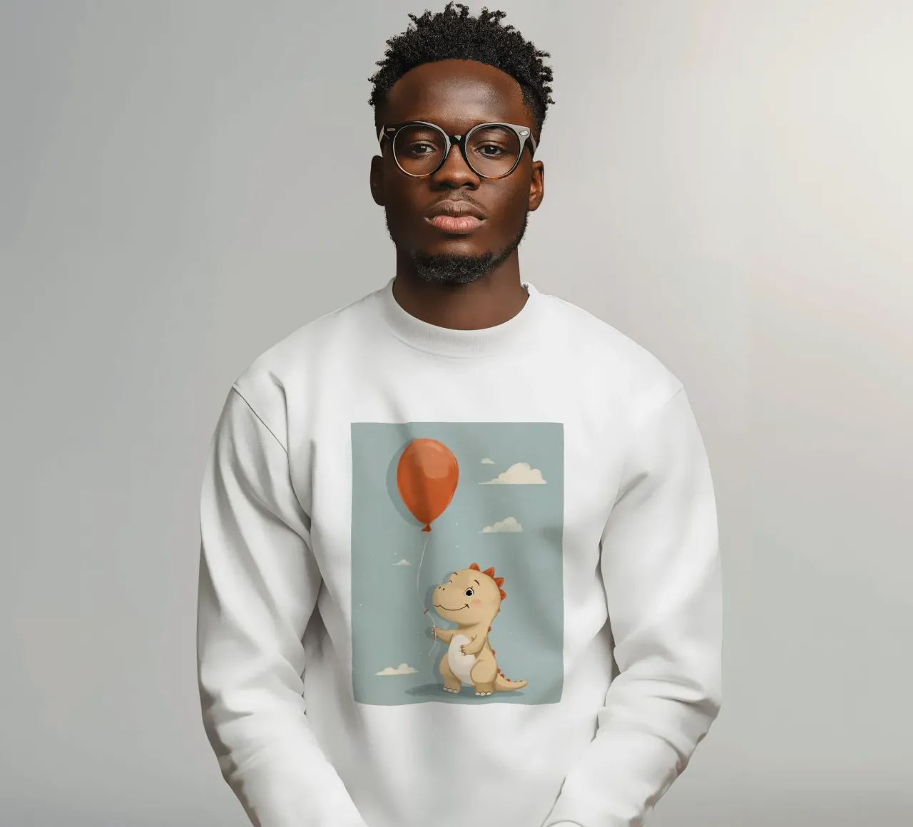 Dinosauro che tiene in mano un palloncino arancione con le nuvole felpa da DesignDoodle