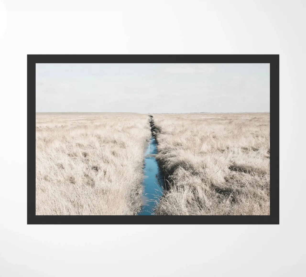 Weids graslandschap met rustige waterloop deurmat van Whole©