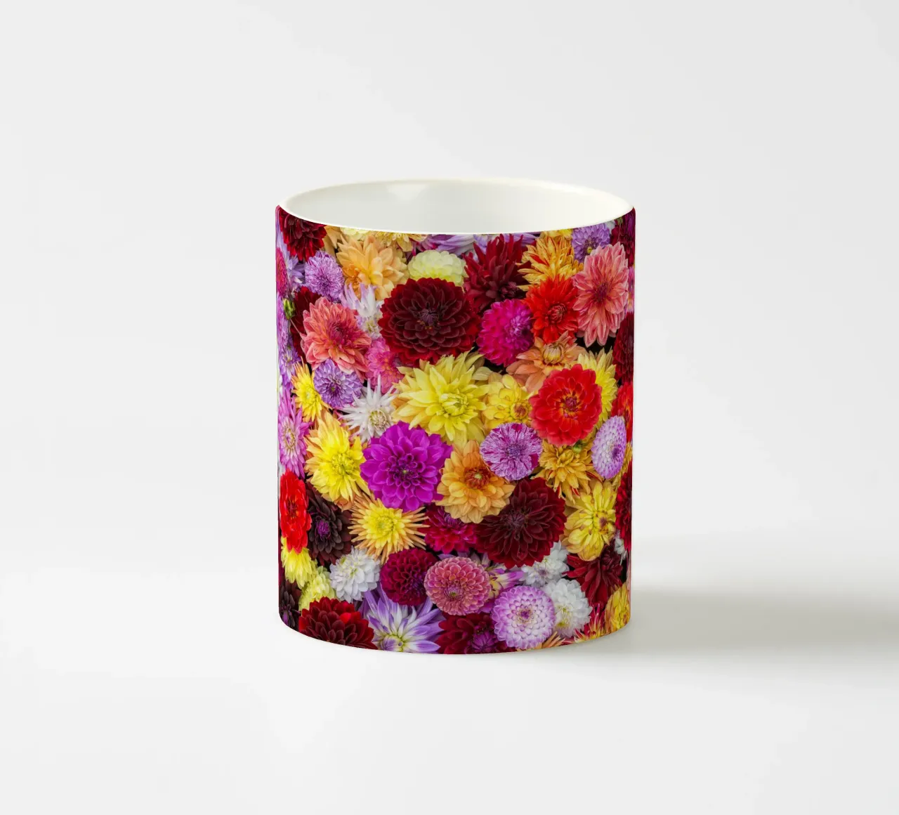 Un arazzo vibrante: Dalie miste in piena fioritura tazza in ceramica da Curious Collections by Marielle Leenders