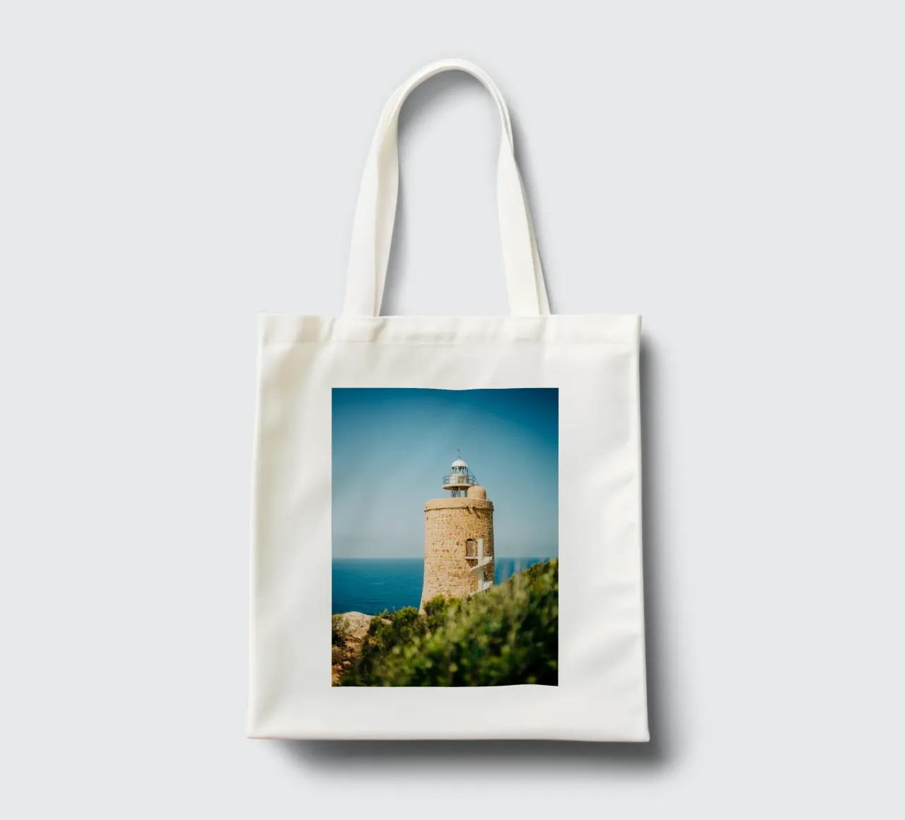 Faro in riva al mare in Spagna, Andalusia con cielo azzurro borsa in juta da Bold and Retro
