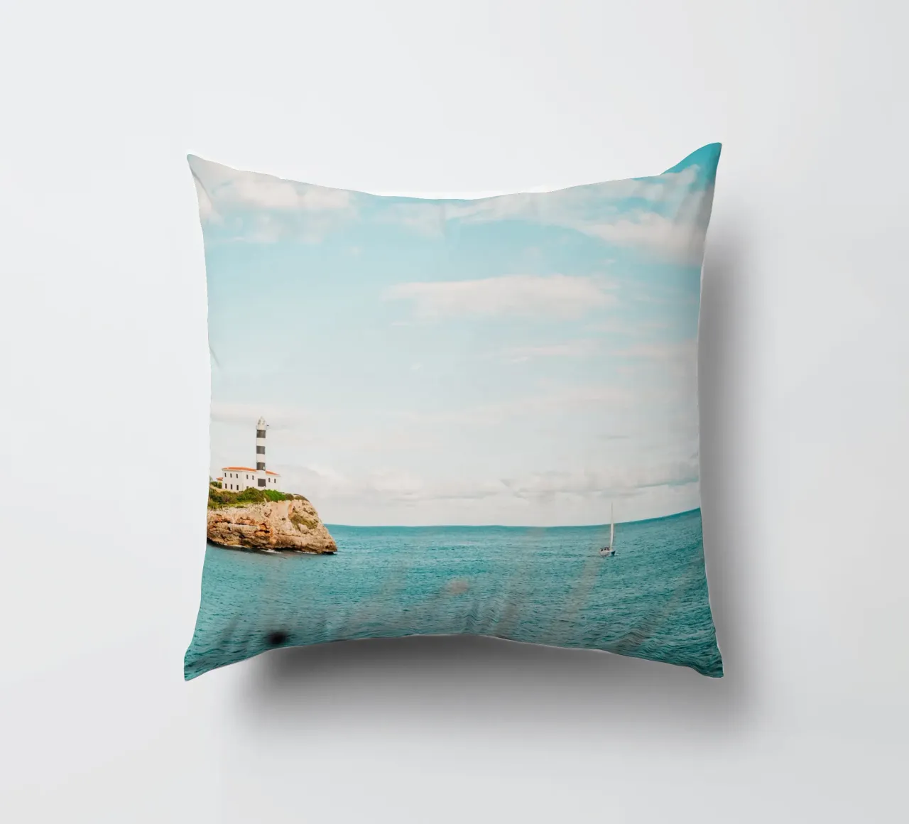 Lighthouse by the sea off Mallorca with sailing boat decorative cushion by Bold and Retro