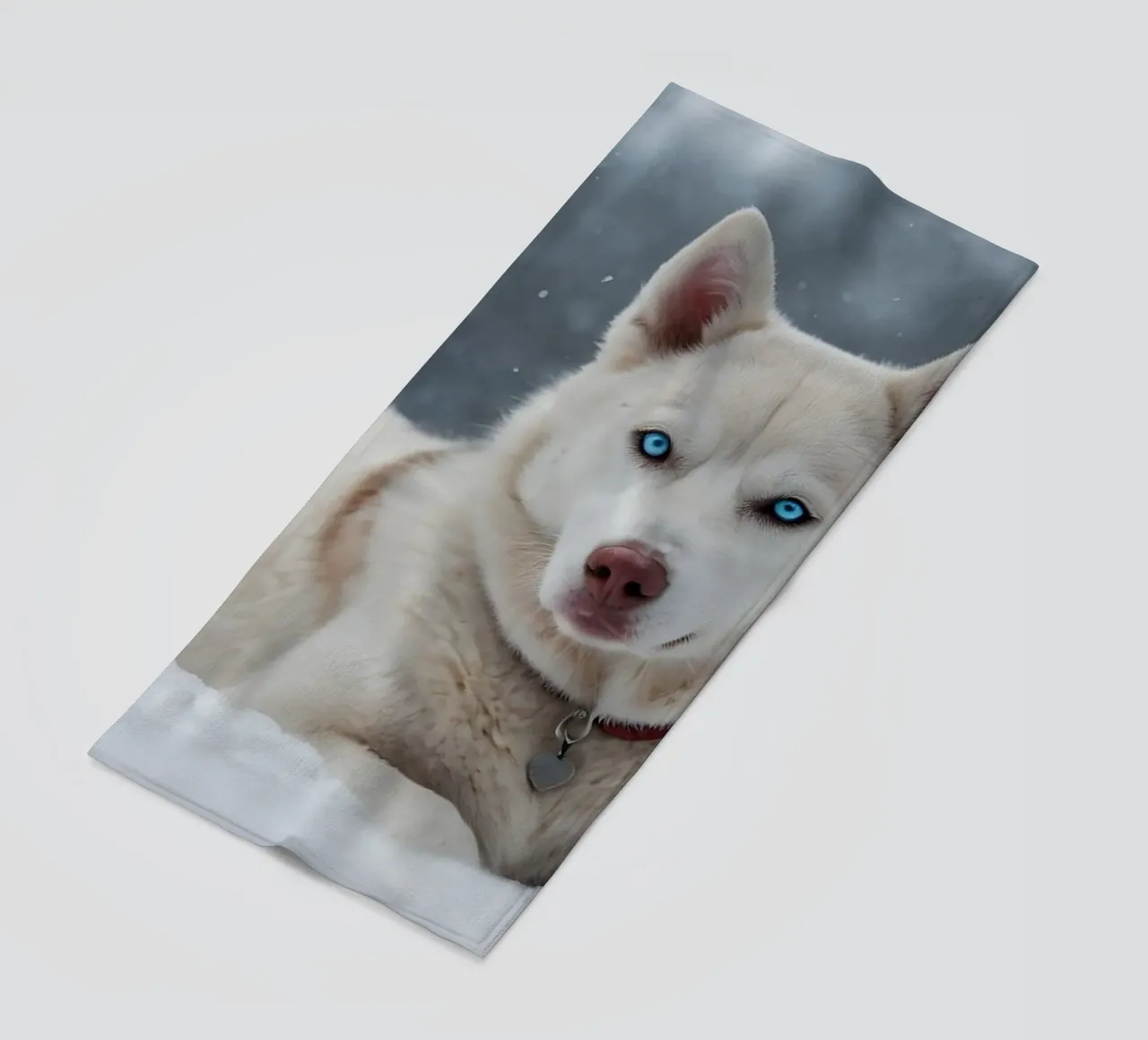 Chien husky aux yeux bleus étonnants se reposant dans la neige blanche et douce serviette de plage de DesignDoodle