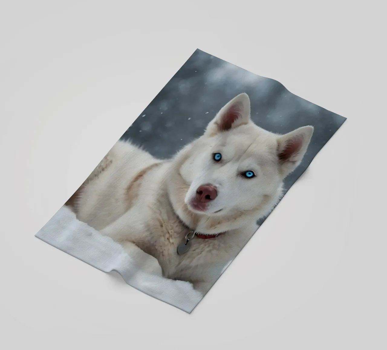 Chien husky aux yeux bleus étonnants se reposant dans la neige blanche et douce serviette de plage de DesignDoodle