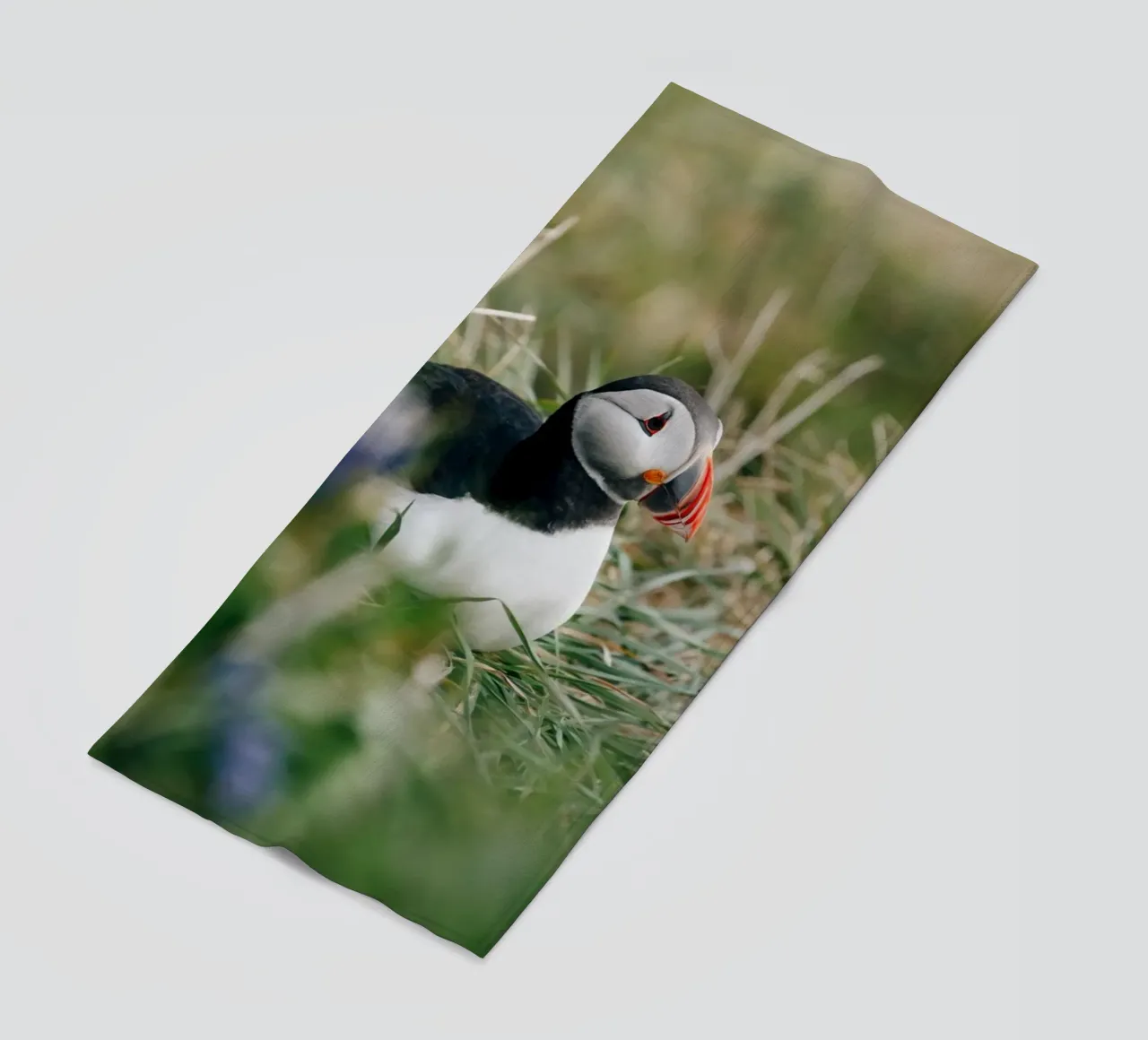 Puffin on a flower meadow beach towel by susea