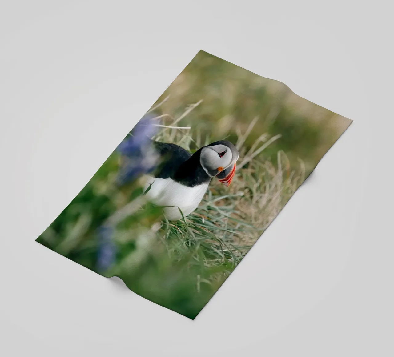 Puffin on a flower meadow beach towel by susea