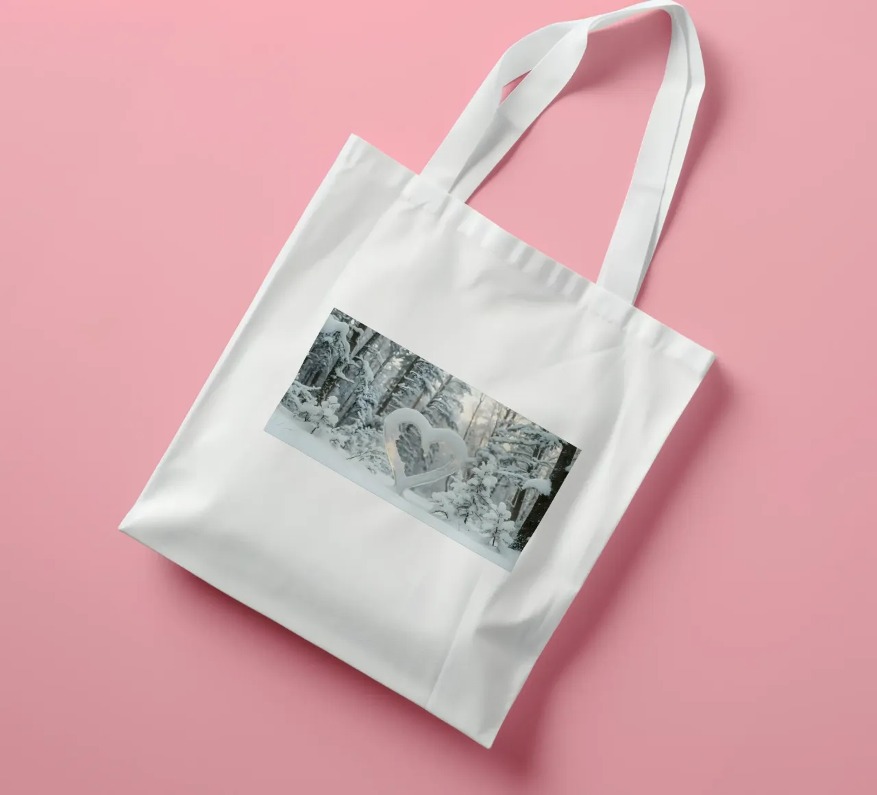 La foresta invernale innevata presenta una formazione di neve a forma di cuore borsa in juta da DesignDoodle