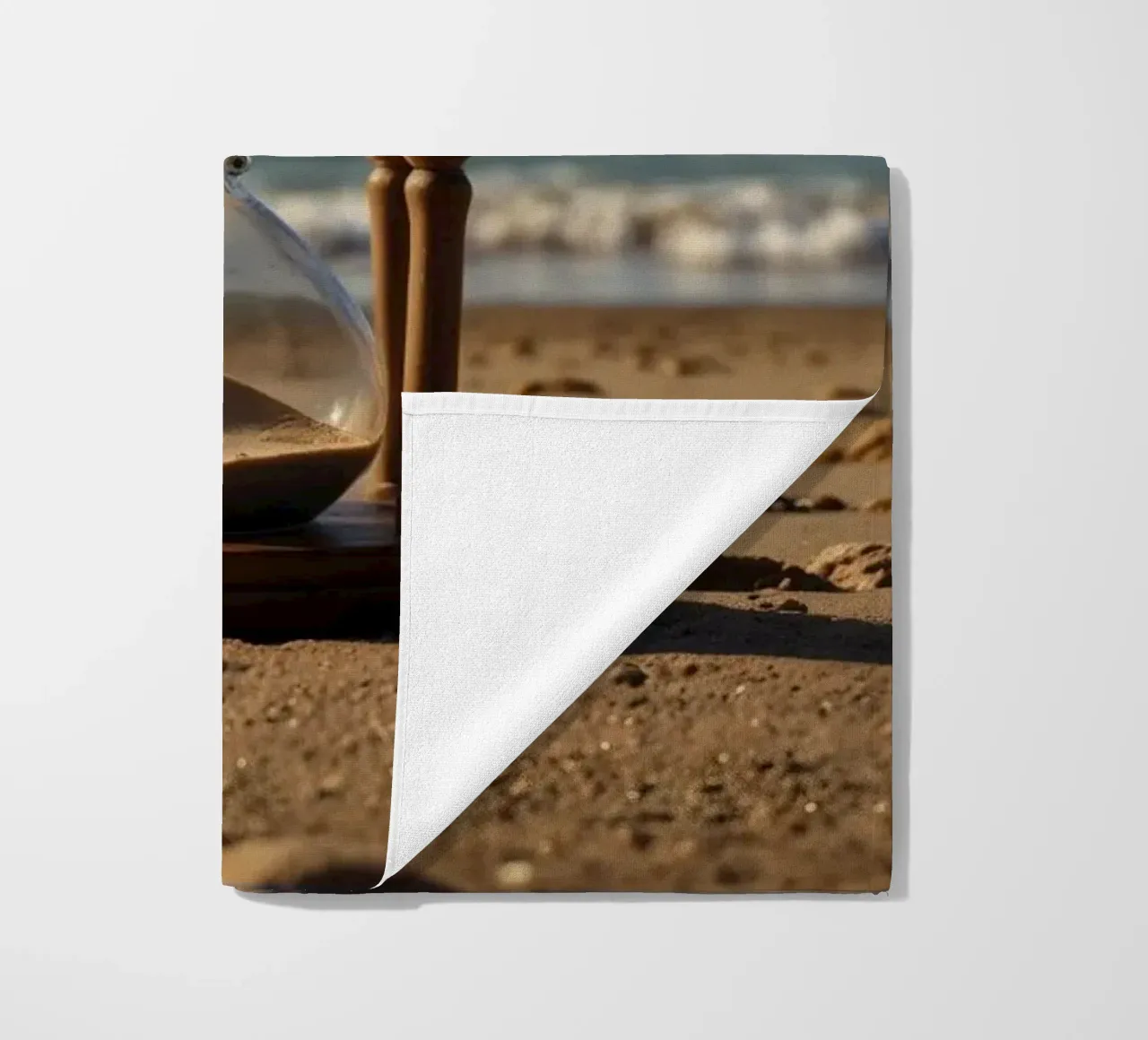 Timer di sabbia posato delicatamente su una spiaggia mentre le onde si infrangono dolcemente telo mare da DesignDoodle