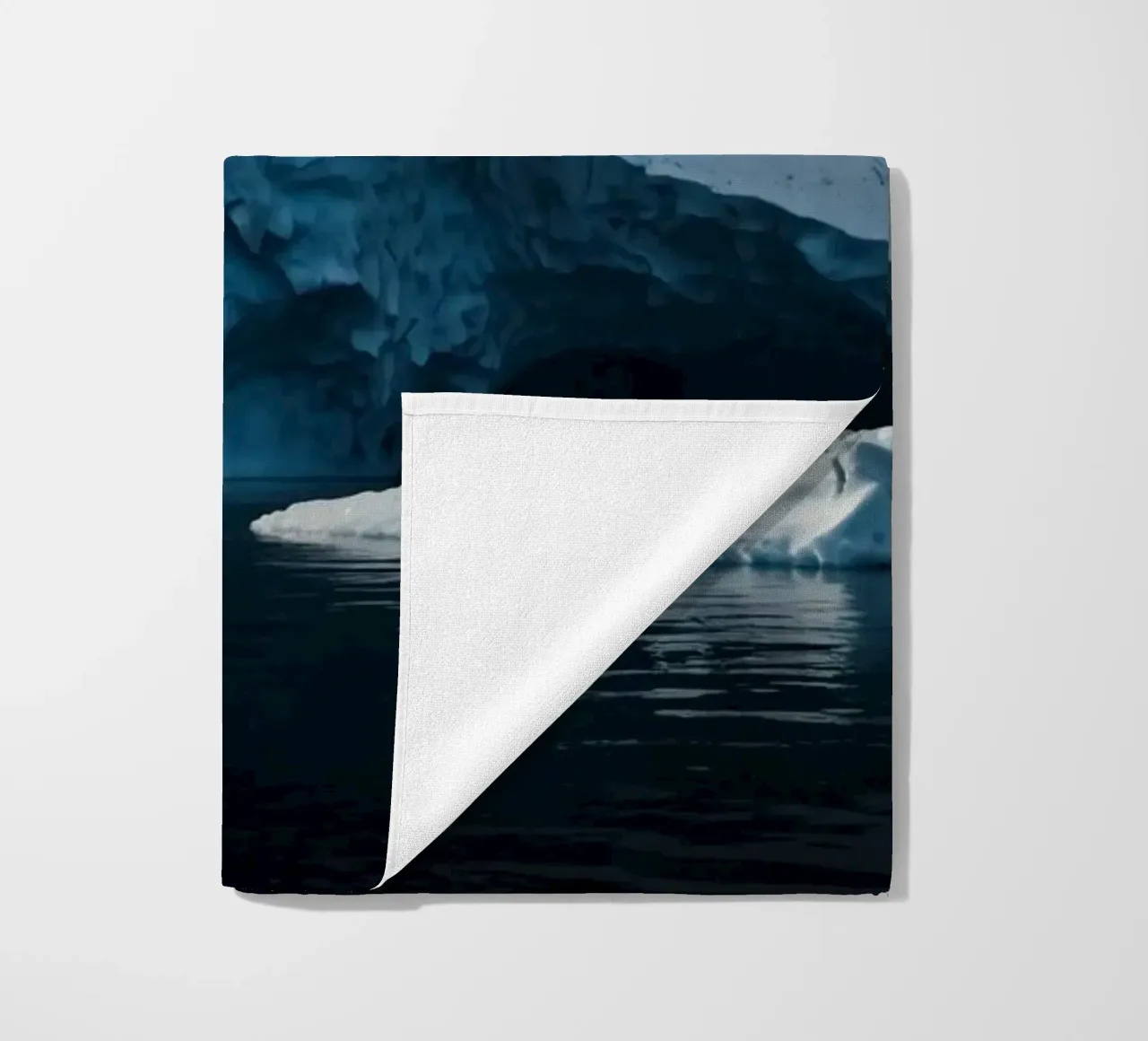 Impressive icebergs reflecting in tranquil waters beach towel by DesignDoodle