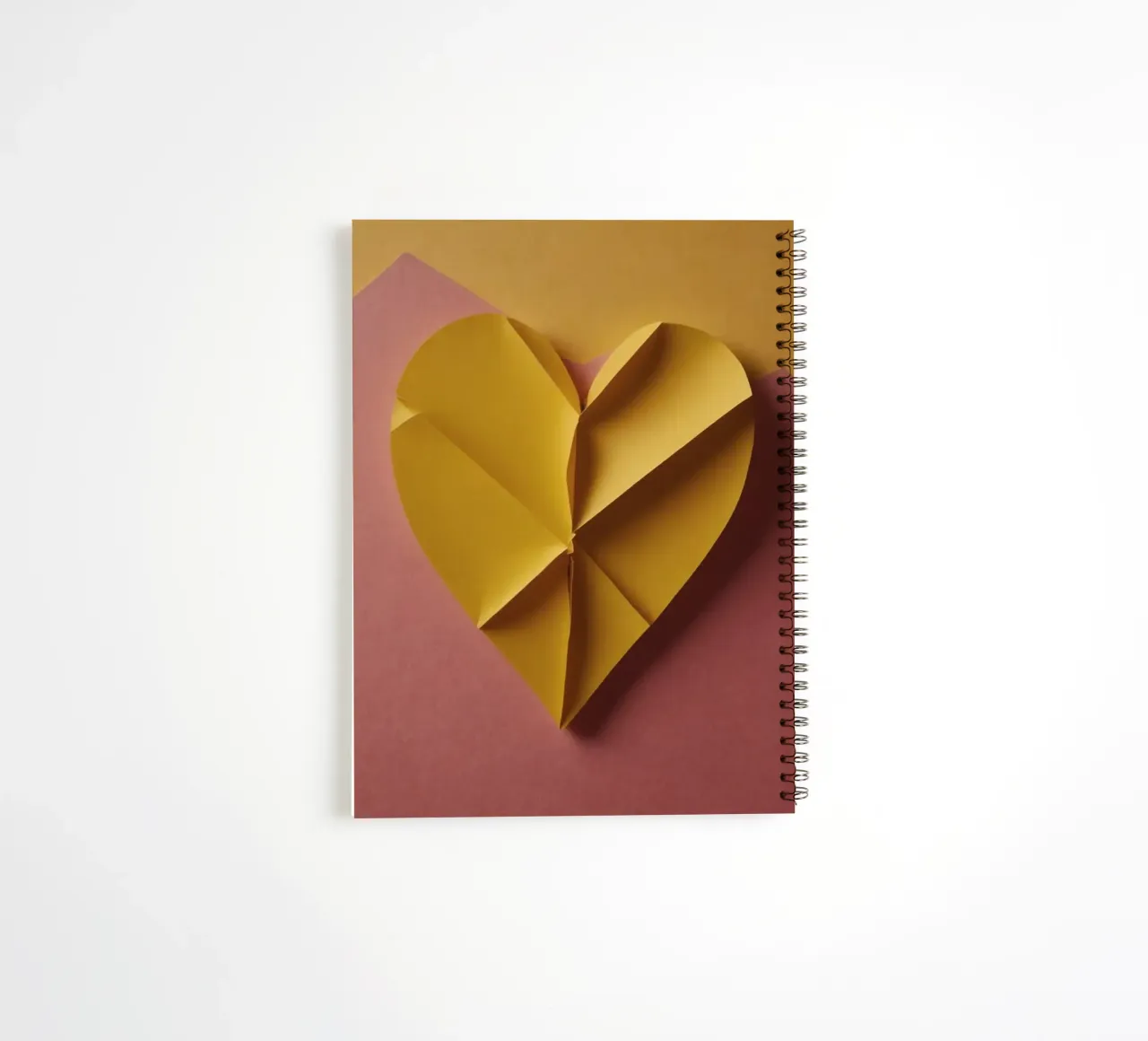 Disegno creativo di cuore origami giallo su sfondo di carta diario ad anelli da DesignDoodle