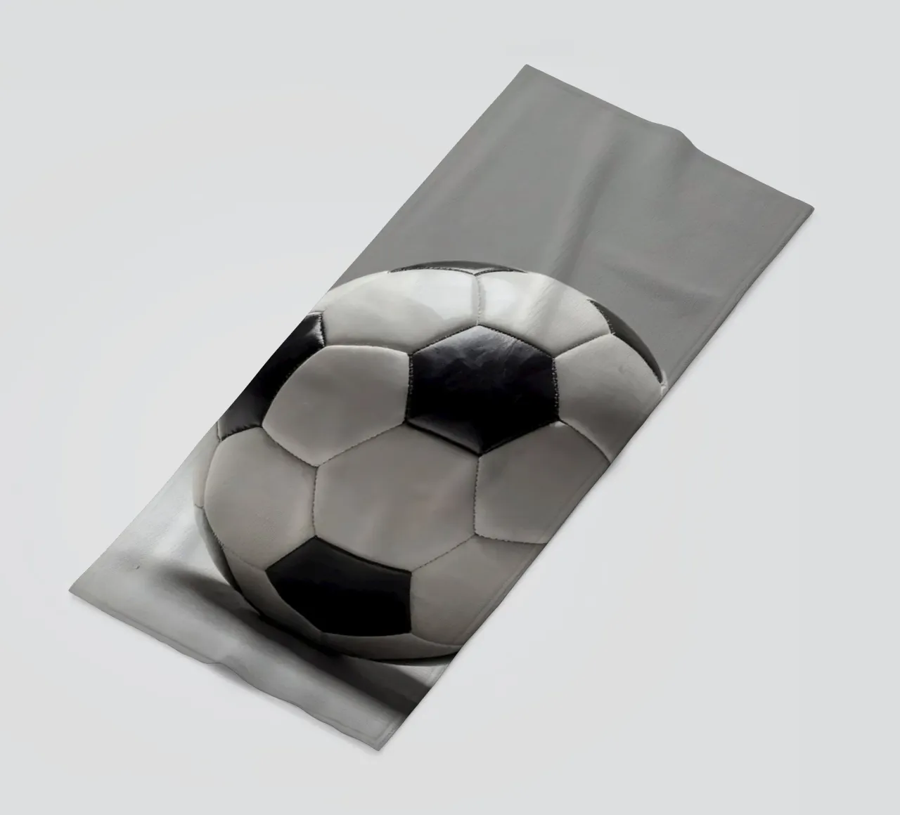 Soccer ball displayed on a plain surface with soft lighting beach towel by DesignDoodle