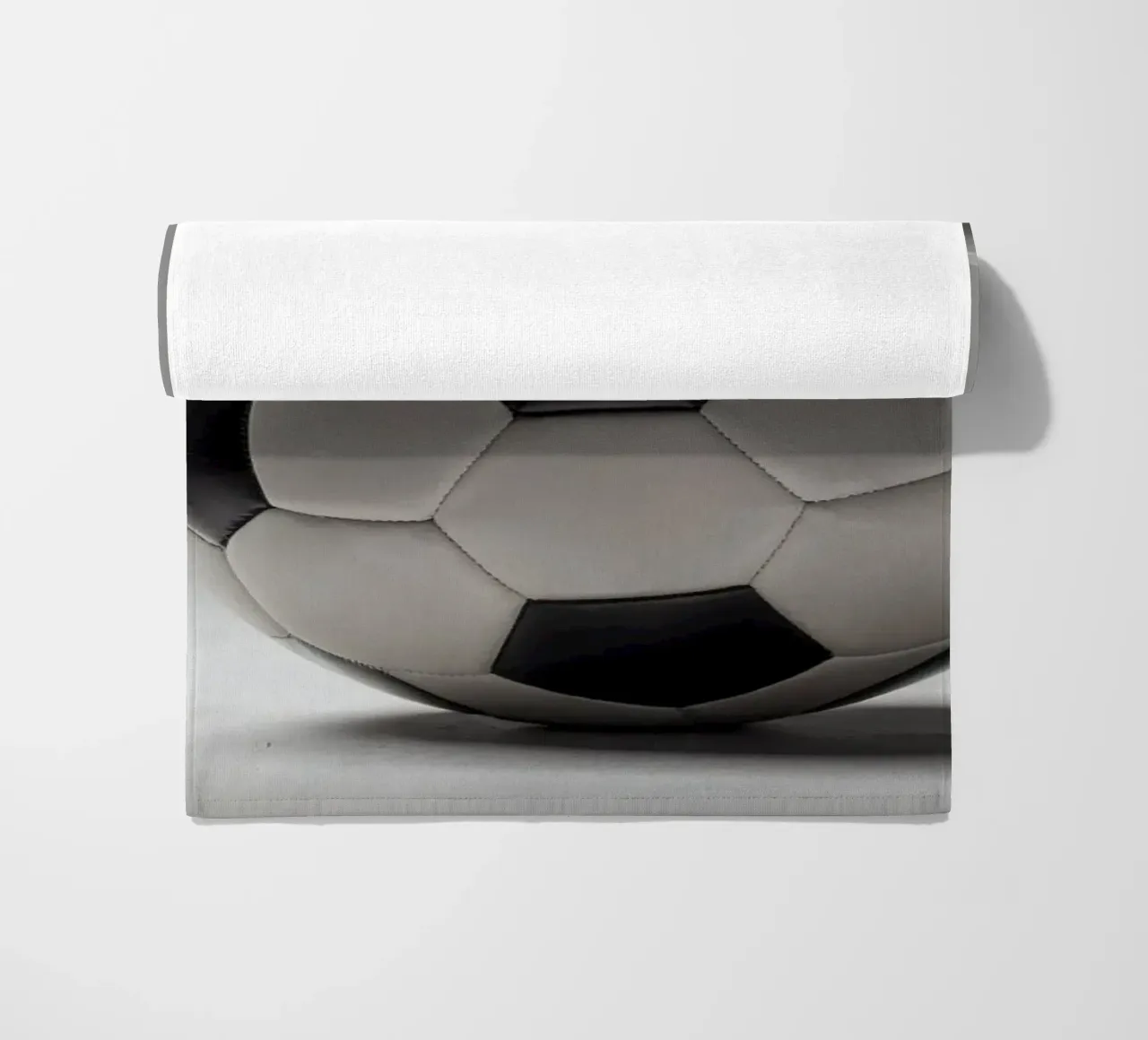 Soccer ball displayed on a plain surface with soft lighting beach towel by DesignDoodle