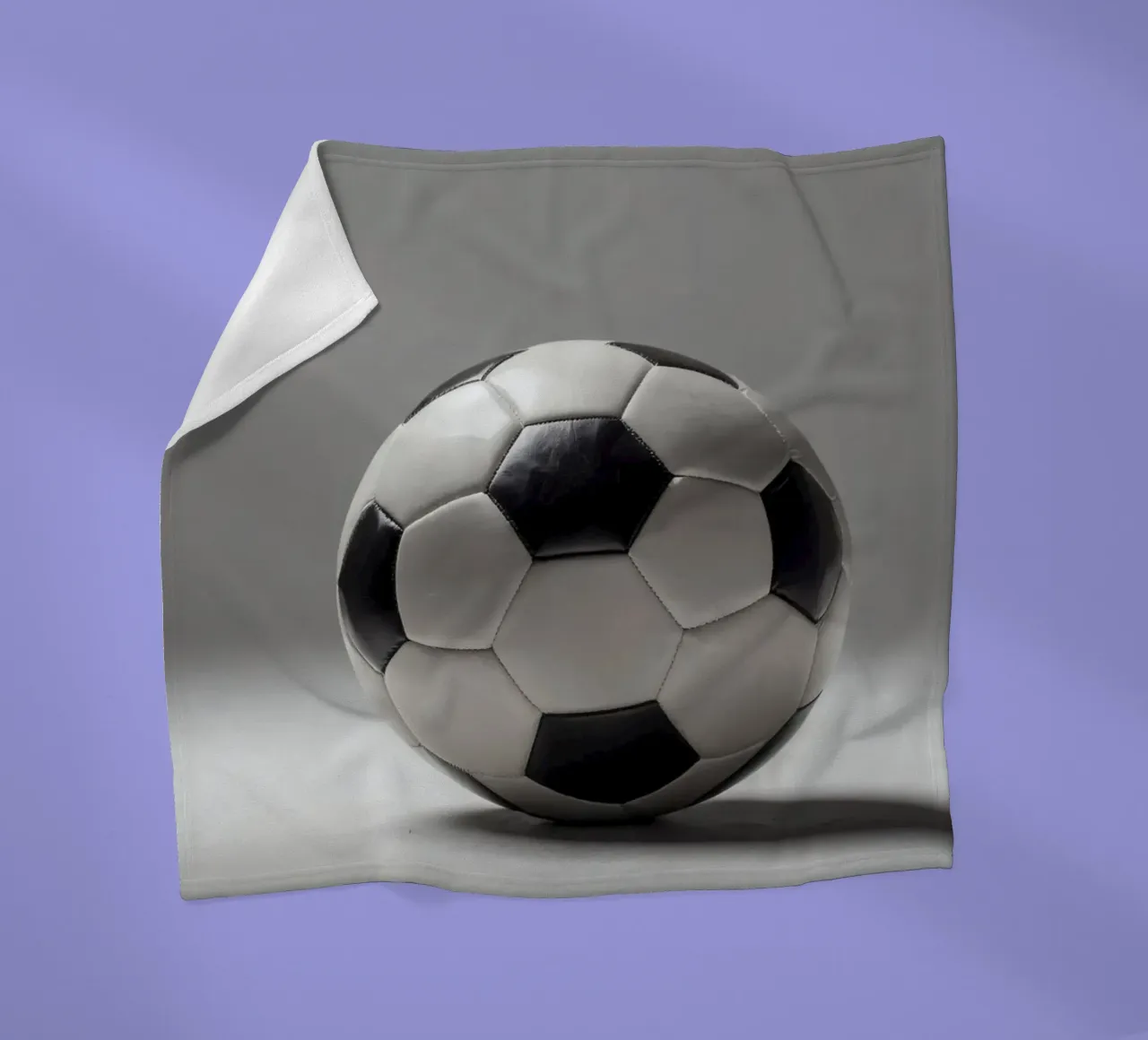 Soccer ball displayed on a plain surface with soft lighting fleece blanket by DesignDoodle