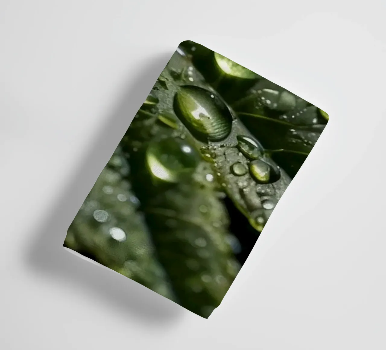 Close-up view of vibrant green leaves covered with dew dropl towel by DesignDoodle