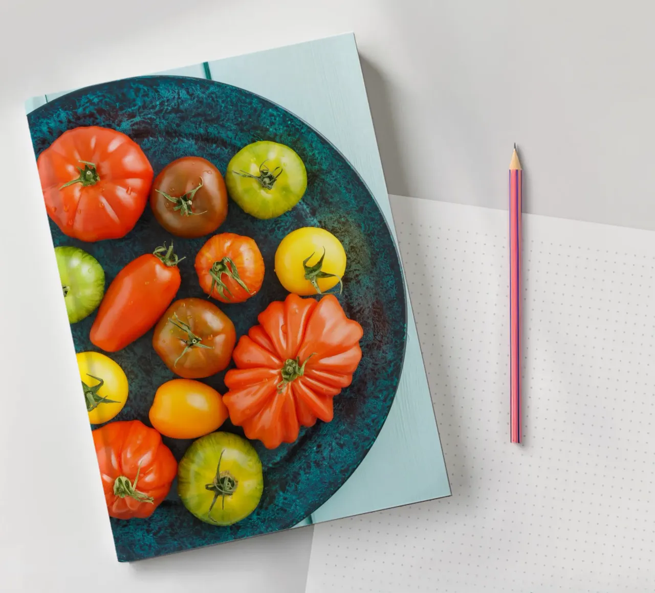 Different types of tomatoes on a rustic plate notebook by foodphotolove