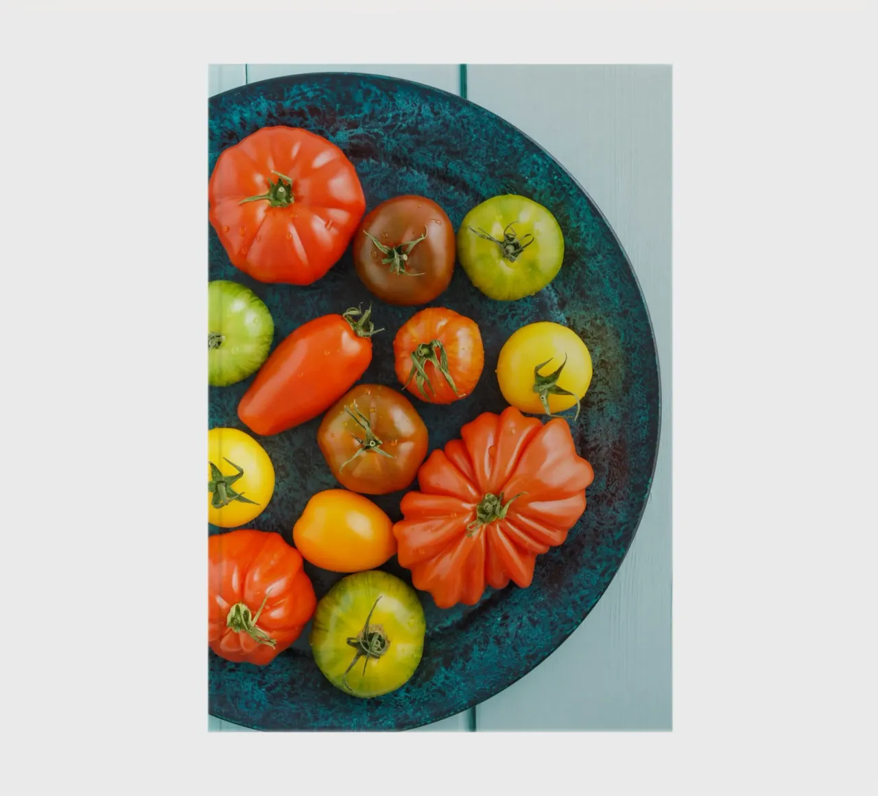 Different types of tomatoes on a rustic plate notebook by foodphotolove