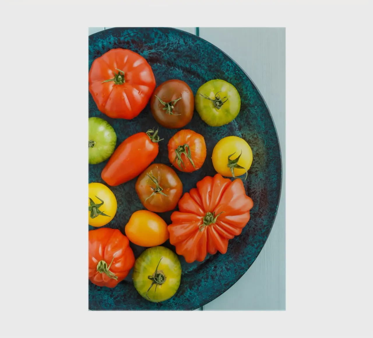 Different types of tomatoes on a rustic plate notebook by foodphotolove