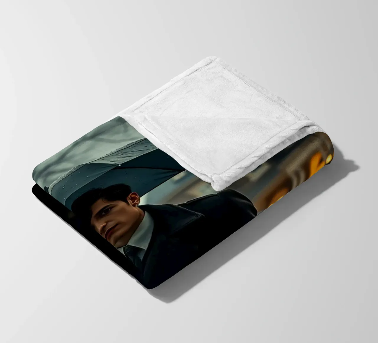 Un giovane uomo si trova sotto un ombrello nero in un autunno piovoso. coperta in pile da DesignDoodle
