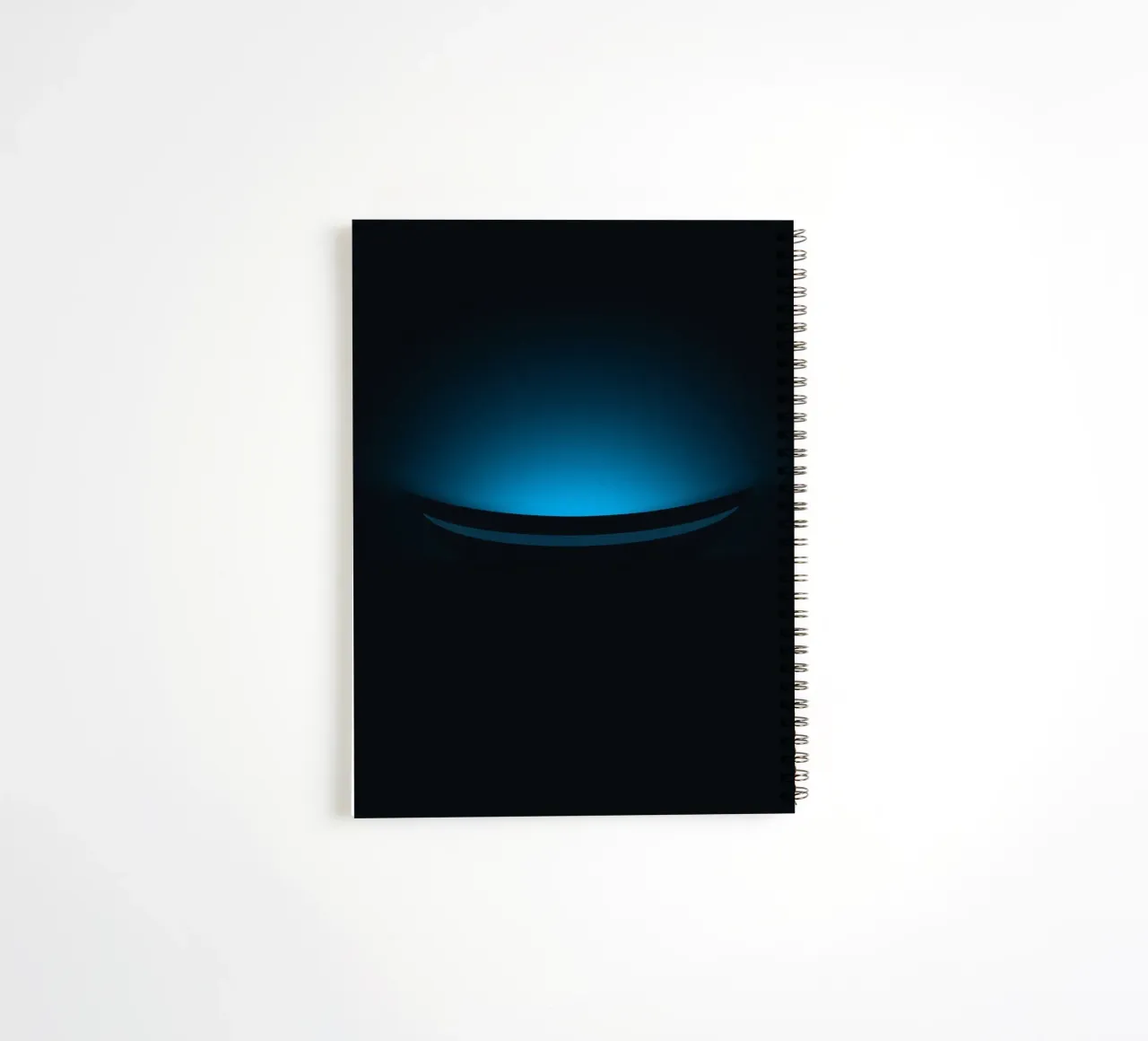 Subtile lueur bleue éclairant une surface courbe dans un décor sombre carnet à spirale de DesignDoodle